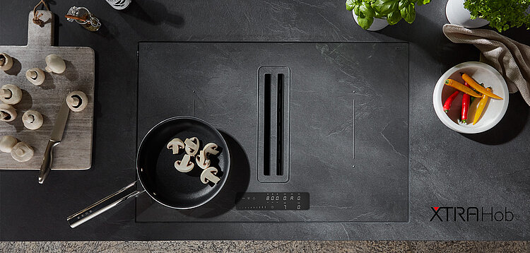 Cuisine moderne avec une plaque de cuisson à induction élégante et des ingrédients frais, offrant un espace culinaire propre et contemporain pour une cuisine maison sophistiquée.