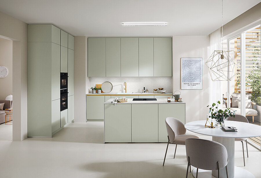 Moderne keukeninterieur met strakke kasten en apparaten in neutrale tinten, met een eiland, eetruimte en overvloedig natuurlijk licht voor een minimalistisch ontwerp.