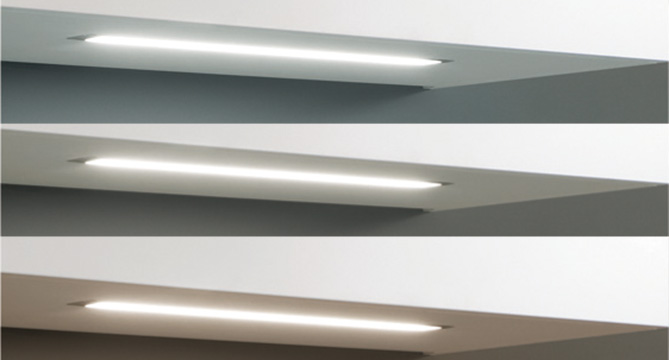 Drei moderne, elegante Leuchten unter Regalen installiert, die ein weiches, diffuses Licht abgeben, ideal für zeitgemäße Innenraumgestaltungen.
