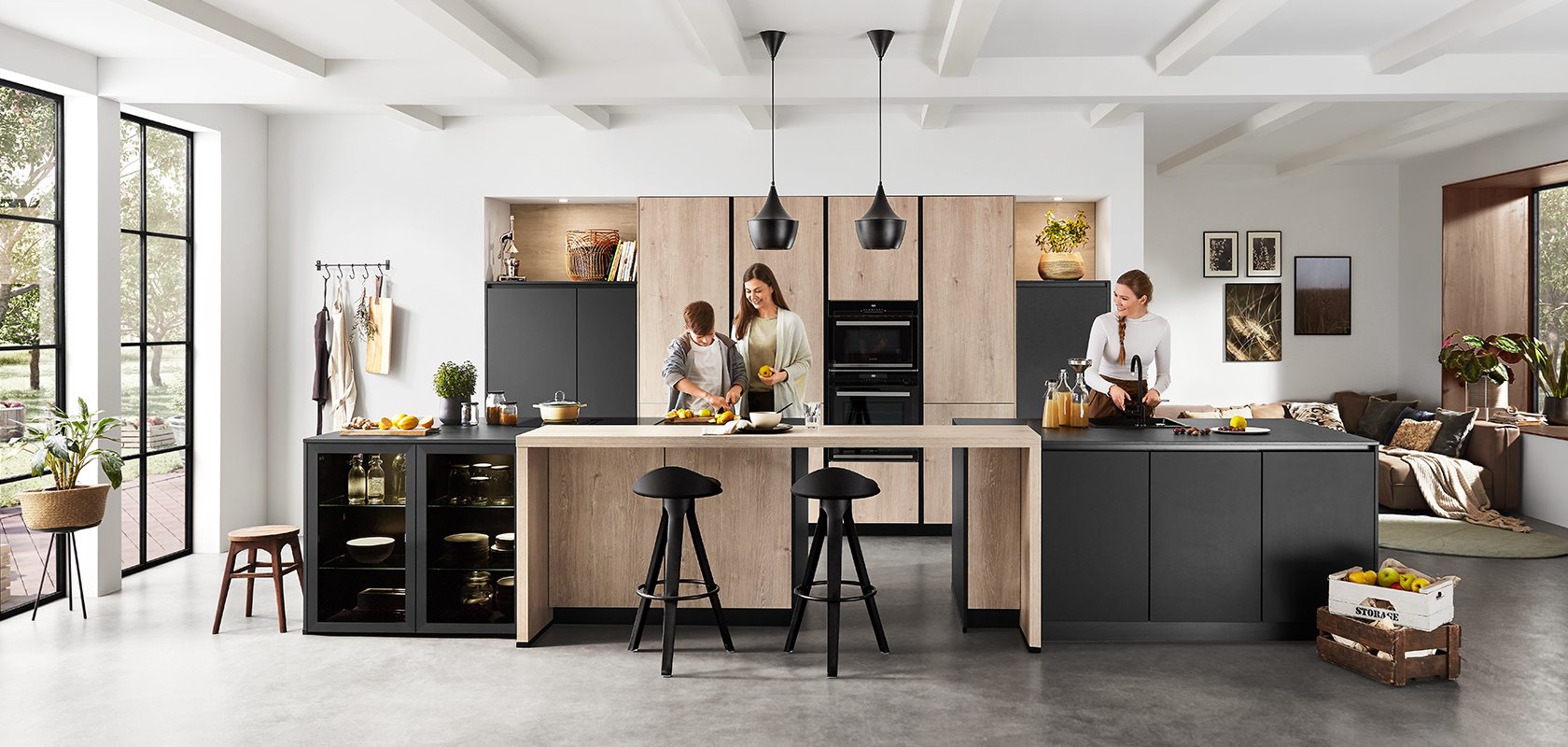 Interior de cocina moderna con un diseño espacioso y limpio que muestra a dos personas cocinando y charlando, resaltando la funcionalidad y el estilo contemporáneo.