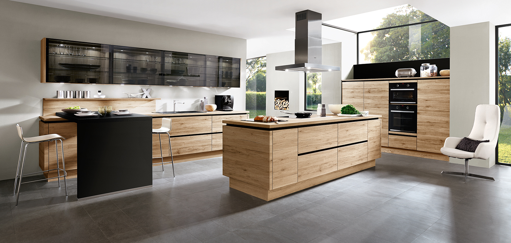 Diseño interior de cocina moderna con electrodomésticos negros elegantes, gabinetes de madera y una isla central con una estética minimalista y abundante luz natural.