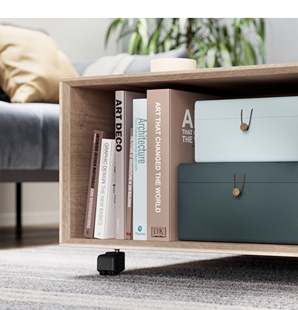 Étagère moderne en bois avec une sélection de livres d'art et de design, accompagnée de boîtes de rangement élégantes, dans un salon confortable.