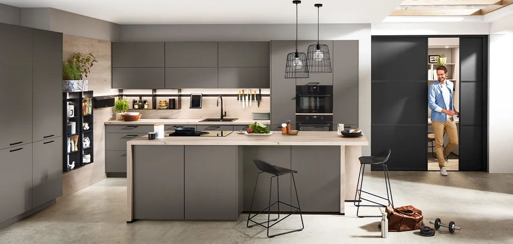 Offene Küche mit integrierter Gleittür für fließende Übergänge zwischen Kochen Arbeiten und Wohnen. Modern und flexibel.