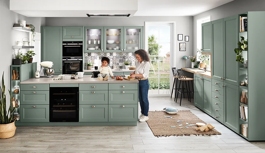 Modern interpretierte Landhausküche in Salbeigrün mit offenen Regalen und Kücheninsel.