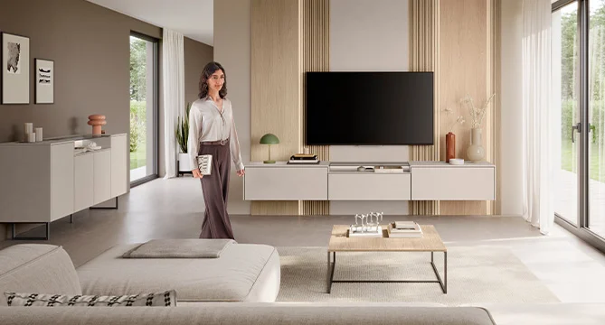 Ein Vater und sein Sohn genießen einen gemeinsamen Moment beim Videospielen in einem hellen, modernen Wohnzimmer, das Wärme und Glück ausstrahlt.