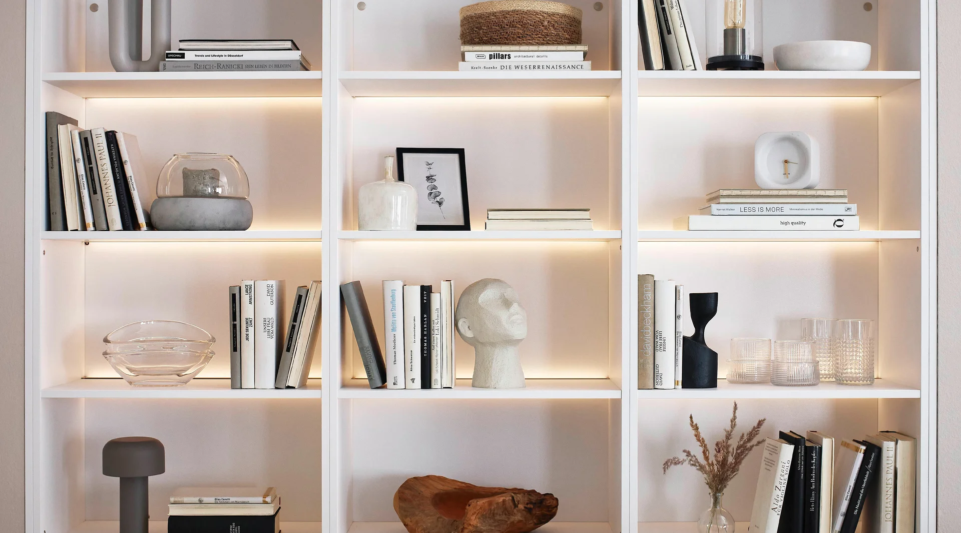 Beleuchtetes Wohnregal mit offenen Fächern, Bücherdekoration und integrierter LED-Regalbeleuchtung.