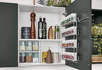 Armoire de cuisine moderne avec des épices, condiments et bocaux soigneusement organisés sur des étagères, dotée d'une solution de rangement d'angle coulissante pratique.