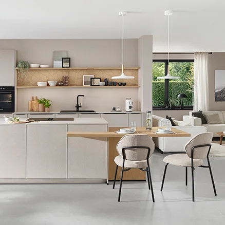 Moderne, helle Küche mit einer großen, zentralen Kochinsel und eleganten Stühlen im minimalistischen Design.
