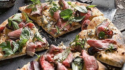 Pizza mit Flanksteak-Streifen: Fleisch vom Grill kombiniert mit traditioneller italienischer Küche: Eine Pizza mit Flanksteak-Streifen verspricht die perfekte Liaison für einen genüsslichen Winterabend.