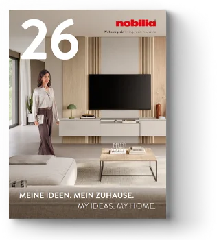 Žena v moderním obývacím pokoji uspořádává předměty na regálu vedle ploché televize, s textovým překrytím: "MEINE IDEEN. MEIN ZUHAUSE. MY IDEAS. MY HOME."