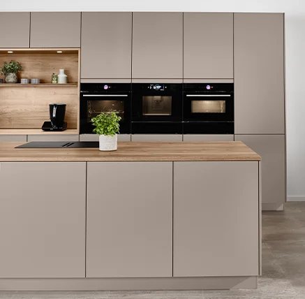 Kücheninsel mit zu 100 % recycelbaren SENSO-Fronten und Arbeitsplatte in Holzoptik vor einer Schrankwand