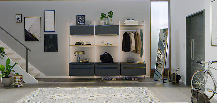 Elegant, modern entryway featuring a minimalist shelving unit with decor, a bicycle by the door, and a cozy rug, embodying contemporary home design.