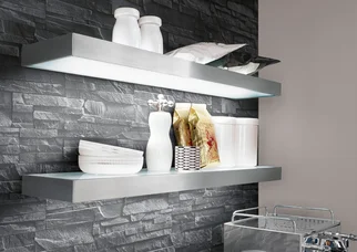 LED-Glaslichtboard für Küchenbeleuchtung mit beleuchteten Wandboards vor dunkler Steinoptik-Rückwand.