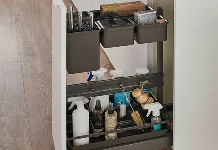 Küchen-Unterschrank in der Front Senso Alpinweiß mit Unterteilung mit schwarzen Behältern für Stauraum von Bürsten und Putzutensilien.