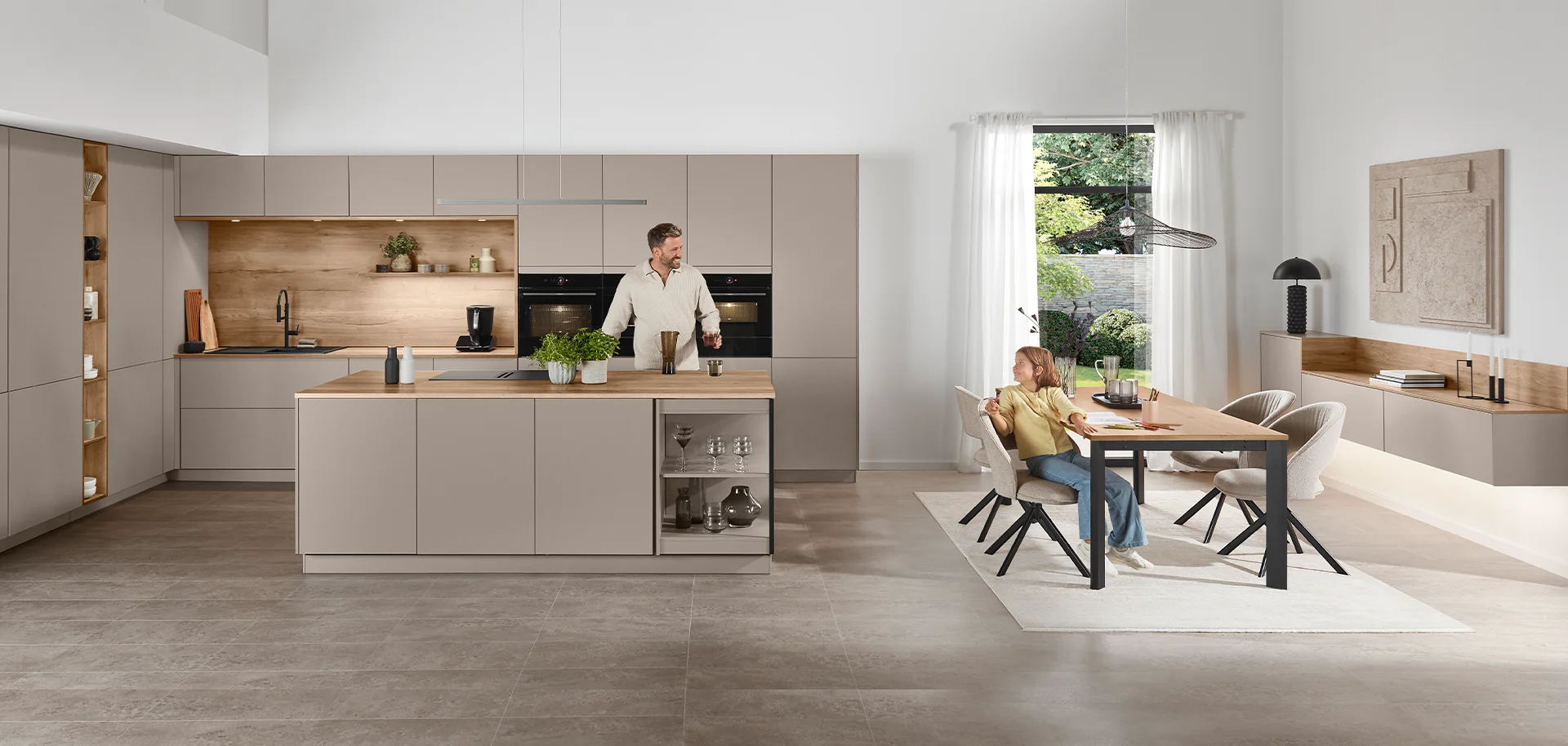 Küche und Wohnraum harmonisch kombiniert mit Möbeln in warmen Macchiato Farben und natürlichen Holzdetails.