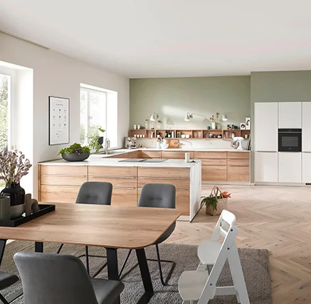 Moderne Küche mit Holzfronten, heller Wandfarbe und elegantem Esstisch in gemütlichem Ambiente