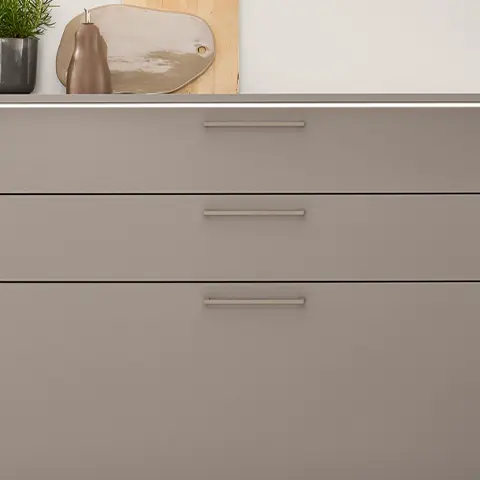 Macchiato-Metallgriff an einer Küchenfront mit drei waagerecht angeordneten Griffen in matter Ausführung