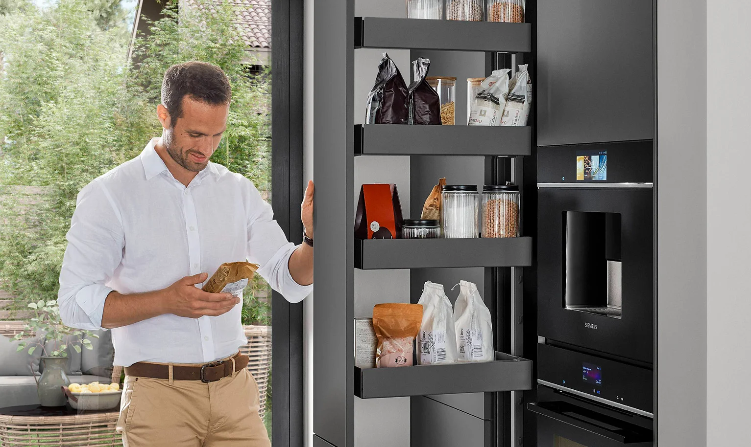 Moderne ergonomische keuken met apothekerskast - de mens gebruikt opbergruimte die van beide kanten toegankelijk is voor snelle en handige toegang.