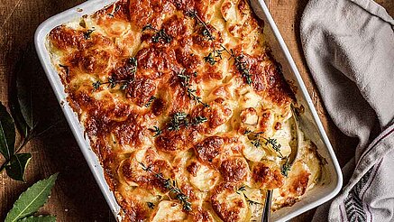 Cremiges Kartoffelgratin: Schicht für Schicht garniert mit Kartoffelscheiben, Creme und Käse kündigt an: Heute wird klassisches, beliebtes Kartoffelgratin serviert!