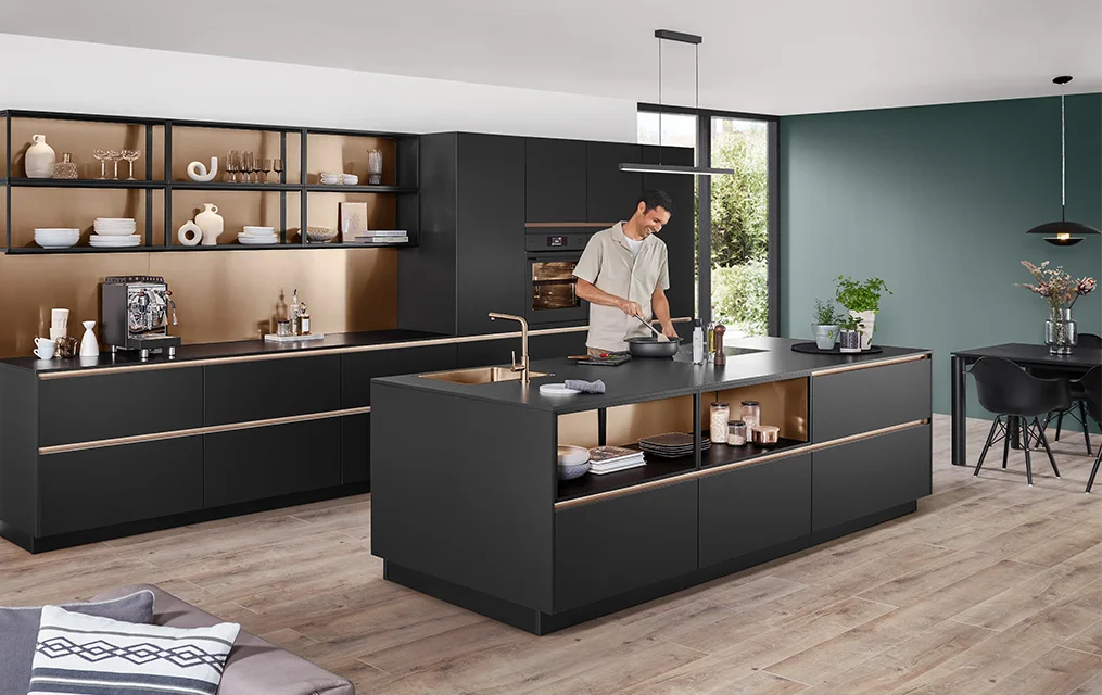 Cucina moderna con frontali in nero premium opaco della linea SENSO 496 e accenti dorati nella zona degli scaffali aperti.