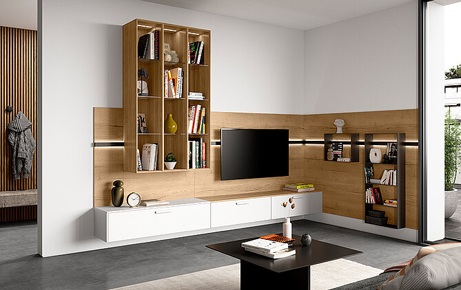 Moderní obývací pokoj s elegantními dřevěnými knihovnami, bílými skříněmi, nástěnnou televizí a útulným posezením s stylovými dekorativními prvky.