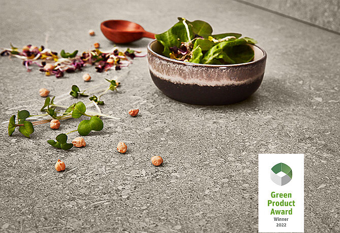 Fresh greens in a rustic bowl with scattered herbs and chickpeas on a textured surface, highlighting eco-friendly culinary excellence.