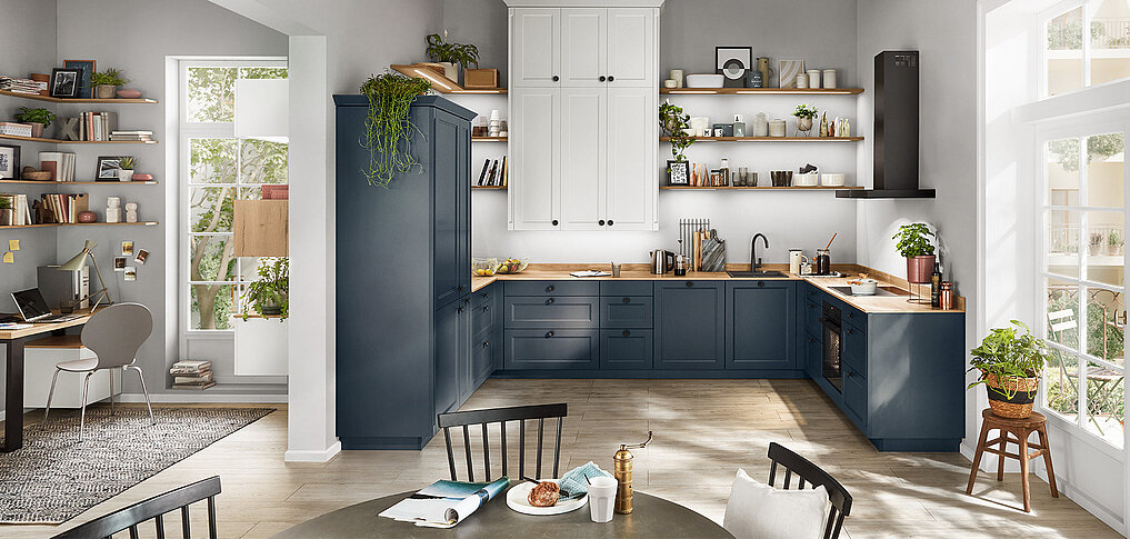Moderne Landhausküche mit Herd und Kochbereich in nobilia Front Cascada 778 in Fjordblau. Die Küche bietet eine elegante Kombination aus blauen Unterschränken, offenen Regalen, weißen Oberschränken und integriertem Arbeitsplatz