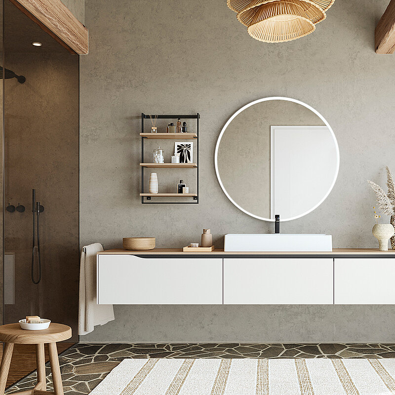 Minimalistický design koupelny s plovoucí toaletním stolkem, kulatým zrcadlem a přírodními doplňky pro klidný a stylový prostor.