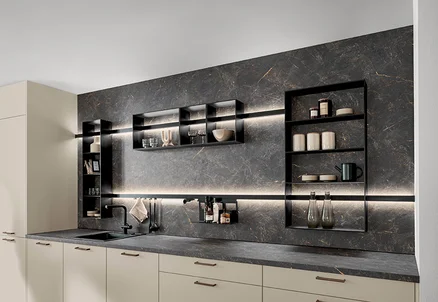 Küche mit Front Softline in Magnolia, dunkler Rückwand, offenen Regalen und integrierter Ambientebeleuchtung.