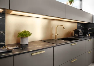 LED-Lichtboden für Küchenbeleuchtung mit bronzefarbener Küchenrückwand über dunkler Arbeitsfläche.