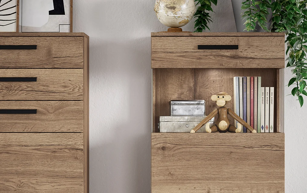 Estantería de madera moderna con decoración minimalista, que incluye libros, una figura decorativa de mono y plantas, realzando una estética de diseño interior contemporáneo y acogedor.