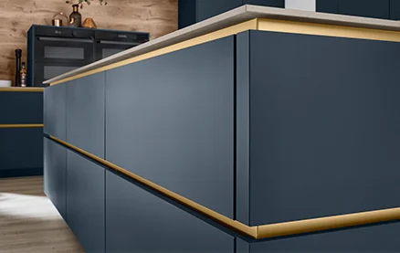 Szczegółowy widok kuchni bez uchwytów z frontem EASYTOUCH 966 w kolorze fjord blue ultra matt i eleganckim, wpuszczanym uchwytem w kolorze złotym.