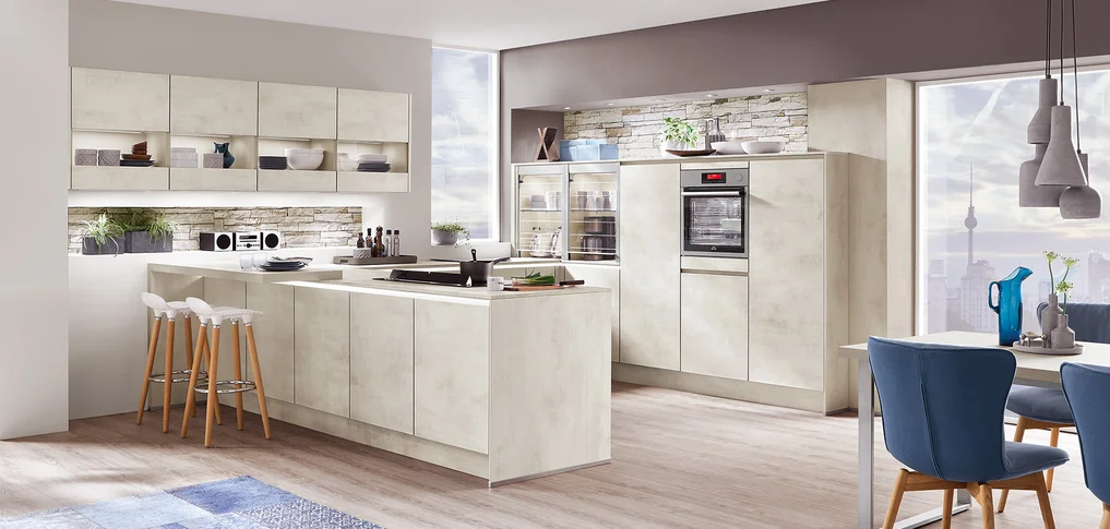 Cette cuisine avec la façade **Riva 891** en couleur **imitation béton blanc** apporte un charme loft urbain dans chaque espace de vie. L'aspect béton clair est à la fois moderne et confortable, idéal pour les cuisines ouvertes sur le séjour. La conception sans poignée souligne le design clair et assure une image d'ensemble calme. Se combine parfaitement avec des matériaux naturels comme le bois et des accents de couleur discrets.