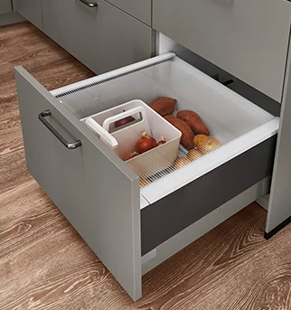 Modern kitchen drawer showcasing an organized storage solution with a built-in compartment for fresh produce like sweet potatoes and onions.