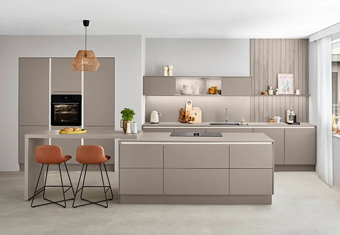 Cocina moderna y minimalista con frentes de color beige, superficies de alto brillo y una elegante lámpara colgante.