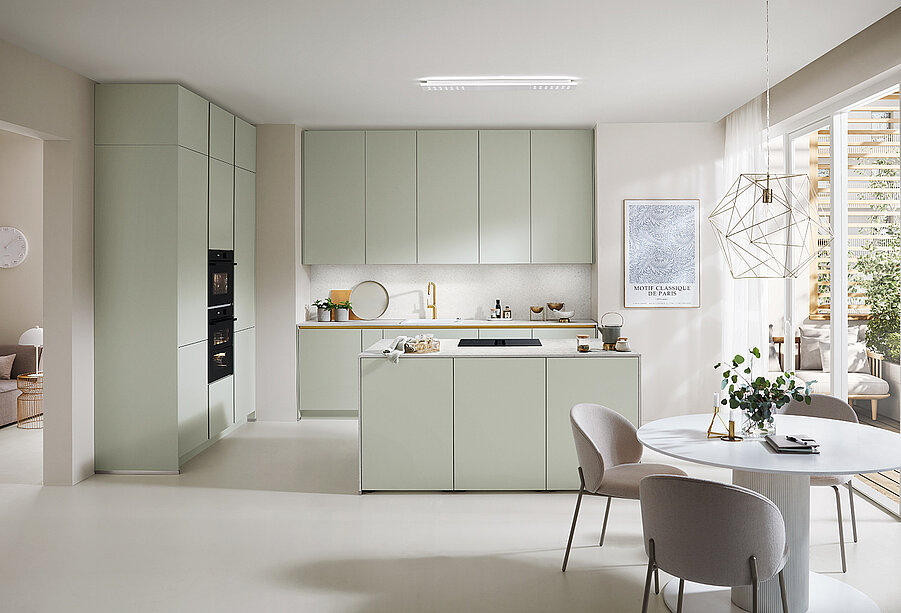 Modern kitchen interior with sleek cabinetry and appliances in neutral tones, featuring an island, dining space, and abundant natural light for a minimalist design.