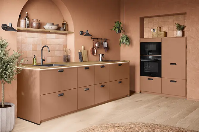 Küche mit strukturierten Fronten in Cotto, Küchenzeile mit Spüle und Backofen-Hochschrank im warmen Wohnambiente