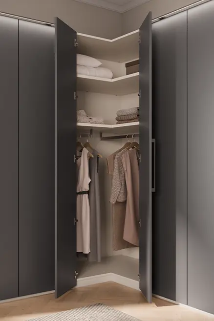 Detailansicht eines Eck-Anbauelements am Kleiderschrank mit offenen Fächern, Kleidung und dunklen Fronten