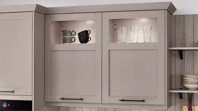 Oberschränke mit Glasrahmen und Kranzleiste setzen leichte Akzente im Landhausstil.