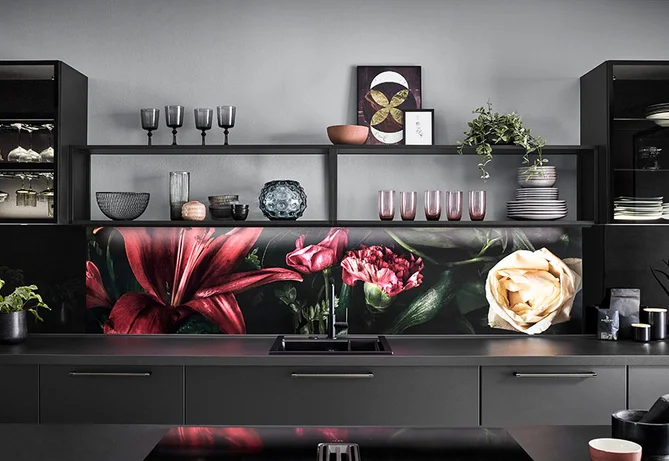 Küche mit Front Touch in Schwarz, indirekter Nischenbeleuchtung und floral gestaltetem Nischenrückwandmotiv.