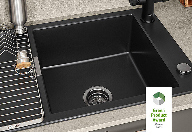 Modern black kitchen sink featuring an angular design, with matching faucet set against a stone countertop, winner of the Green Product Award 2022.