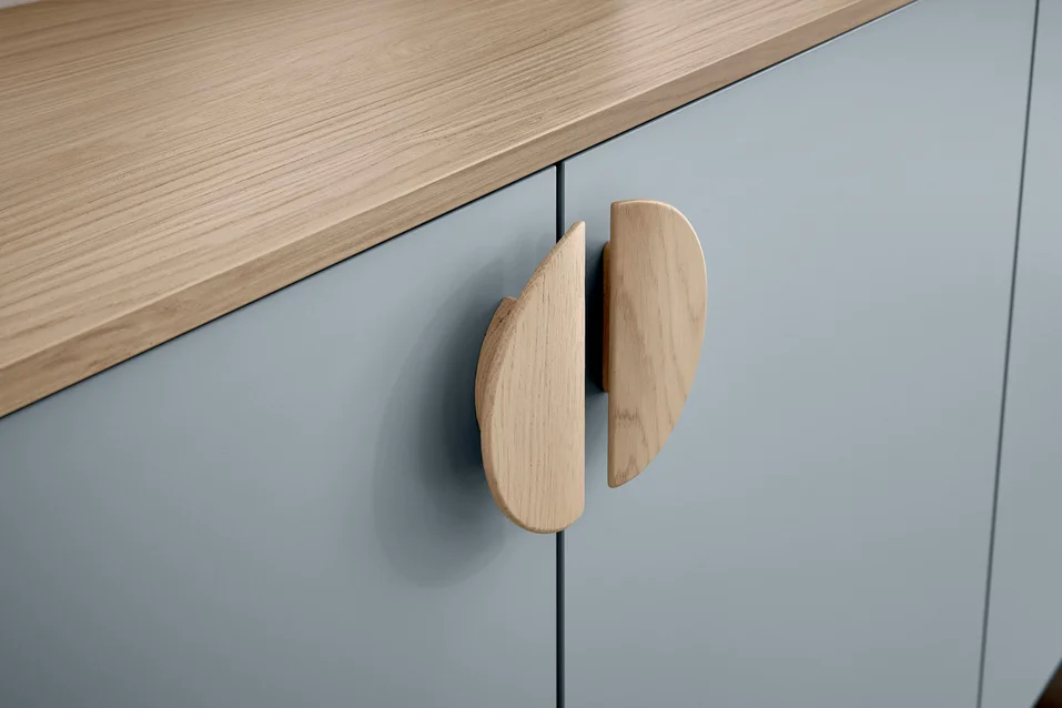 La superficie de madera natural contrasta con la superficie azul mate de los armarios.