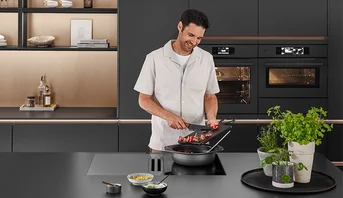 Moderne Küche mit Front SENSO 496 in Antifingerprint und Xtra Hob in Matt Schwarz. Stilvoll, funktional und pflegeleicht.