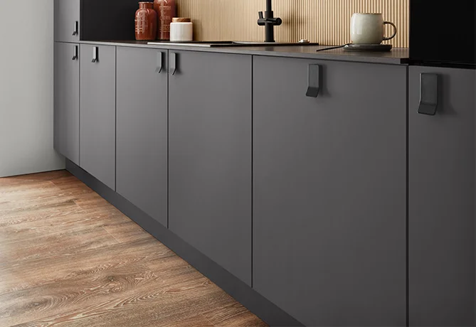 Bild von einer Küche mit dem Fokus auf die schwarzen Metallgriffe.