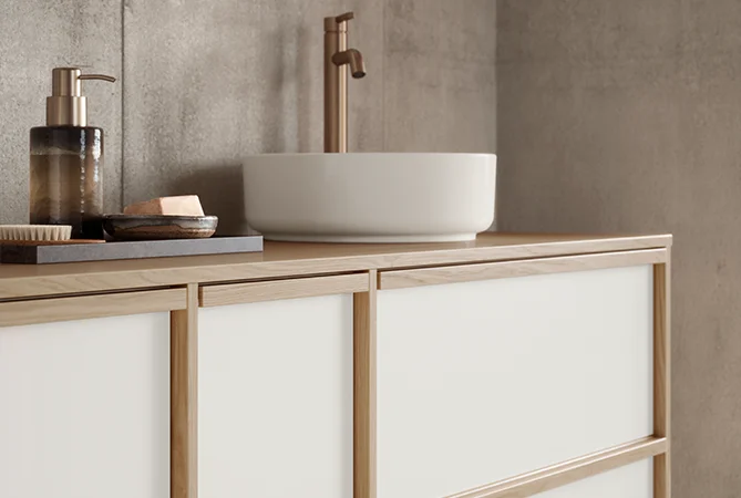 Meuble de salle de bains stylé au look Japandi avec robinetterie couleur bronze & accessoires harmonieux à l'aspect cadre en bois.