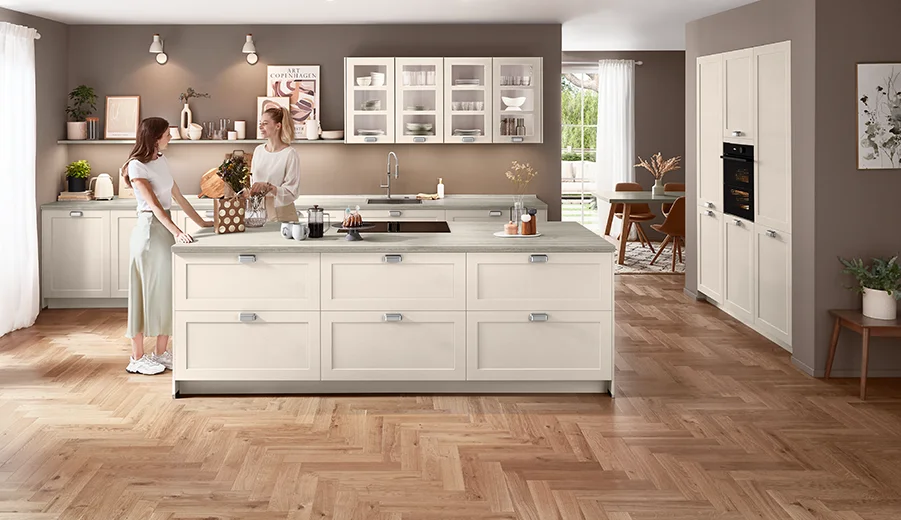 Nordisch inspirierte Küche in zartem Grün mit Kassettenfronten und dunkler Arbeitsplatte.