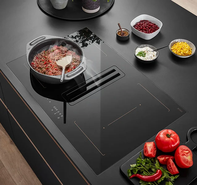 Superficie de cocina de alta calidad con tomates, judías y hierbas aromáticas, así como vajilla para la preparación de los platos.