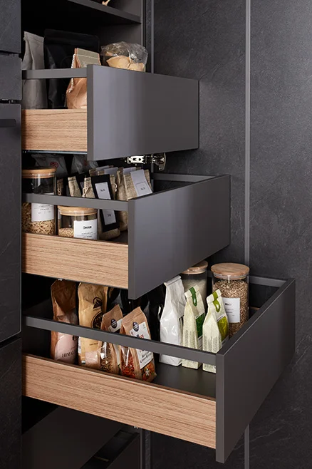 [Translate to pl:] nobilia nBOX Schubkastensystem mit Holz Profil Cover in natürlicher Eicheoptik für moderne Innenorganisation in der Küche passend zur Front Stoneart 303 in Grauschiefer Nachbildung mit durchdachter Aufbewahrung für Vorräte und Küchenutensilien