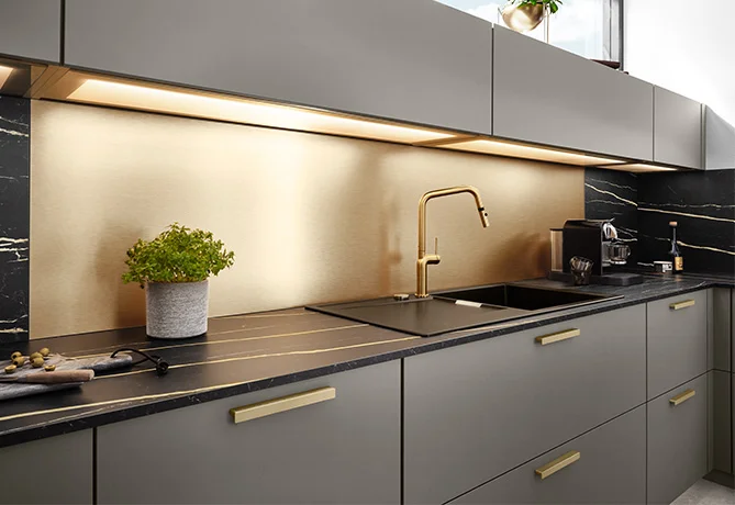 Bild einer Küche mit dem Fokus auf die goldfarbene Küchenrückwand.