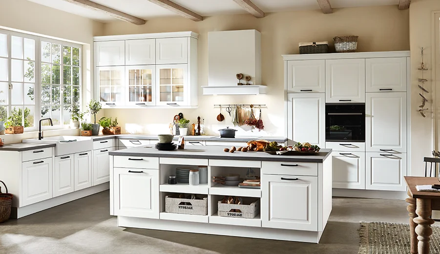 Kuchnia w ciepłym dekorze drewna z elementami wiejskiego domu i efektownymi czarnymi uchwytami.